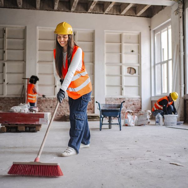 Construction worker sweeping renovation site.