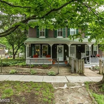 Charming two-story Craftsman-style duplex with front porch and mature trees