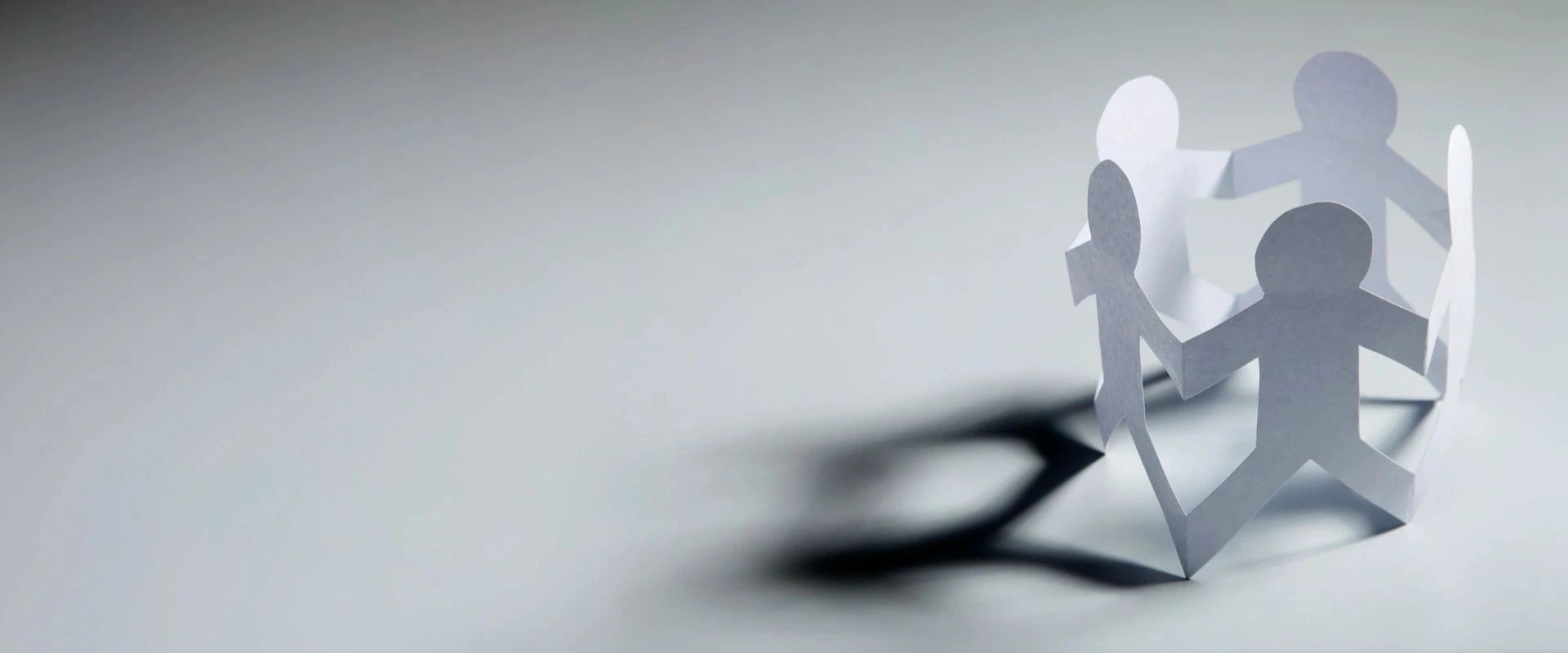 Paper cutouts holding hands together.

