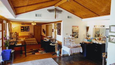 Cozy room with wooden ceiling, tables displaying baked goods and decor.