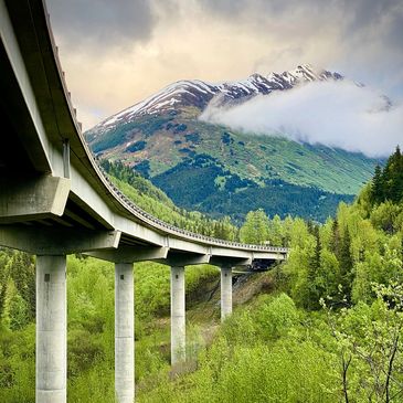 Seward Highway bridge near Hope Alaska has a beautiful view of the Alaskan mountains as you're trans