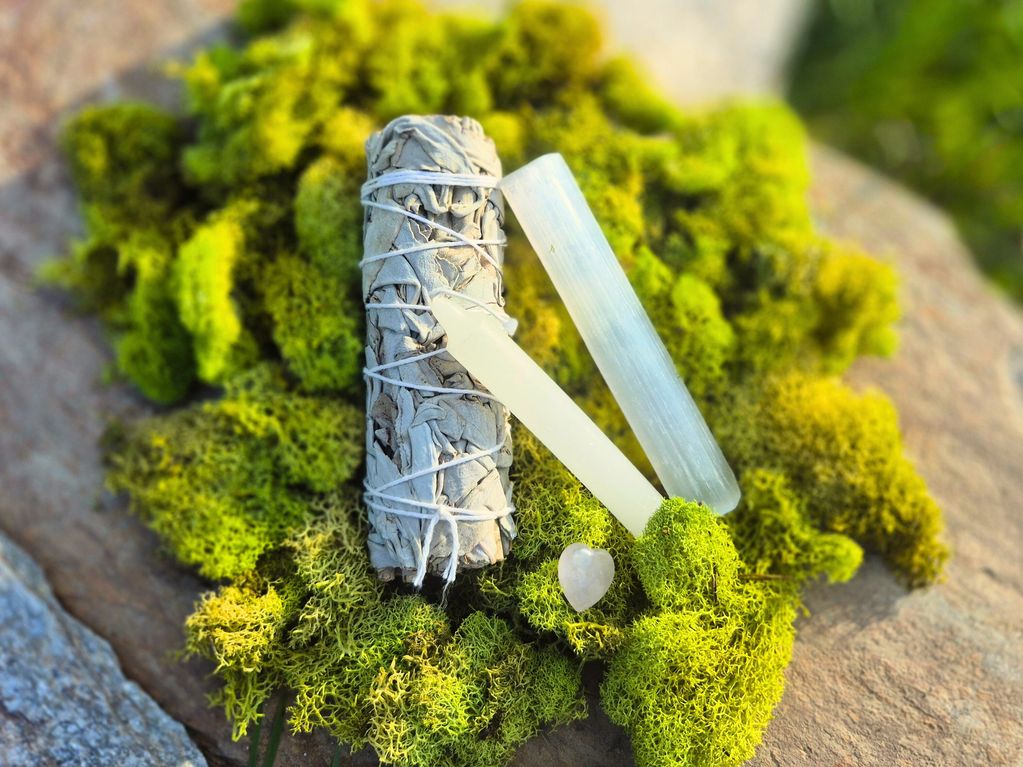 A serene Cleansing Bundle with white sage, selenite wand, and candle.
