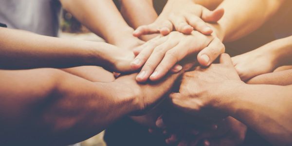 Multiple hands stacked together symbolizing unity and teamwork.