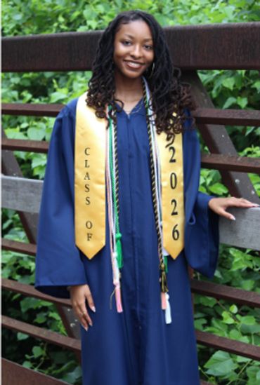 Young woman in navy graduation gown with yellow stole.