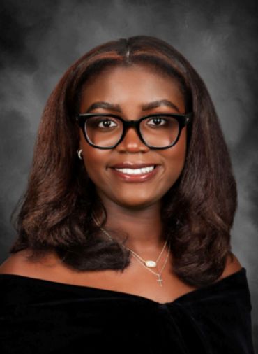 Smiling woman with glasses and shoulder-length hair.