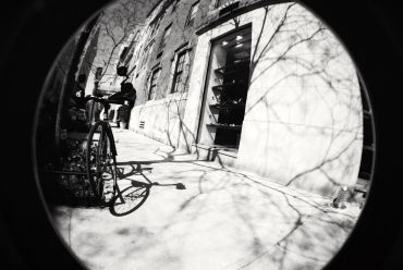 Fisheye view of a bike and building entrance with shadows.