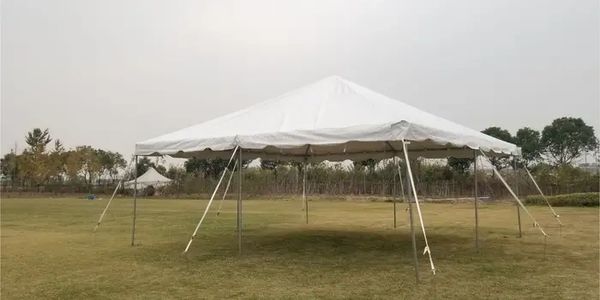 Large white outdoor canopy tent set up on a grassy field.