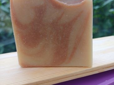 Handcrafted soap with swirled earthy tones on a wooden surface.
