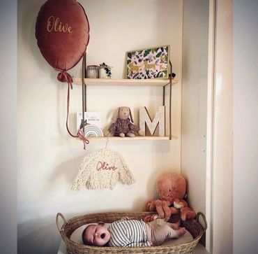 Baby nursery room with personalised cardigan and balloon
