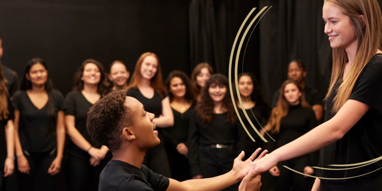 Young man proposing to a smiling woman in front of a group.