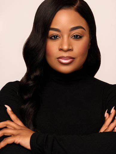 Confident woman with long black hair in black turtleneck.