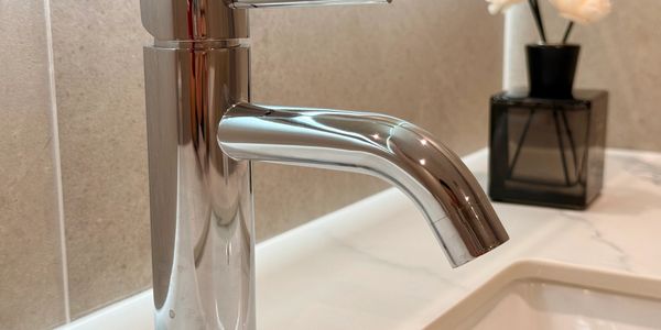 Close-up of a modern chrome faucet on a bathroom sink.