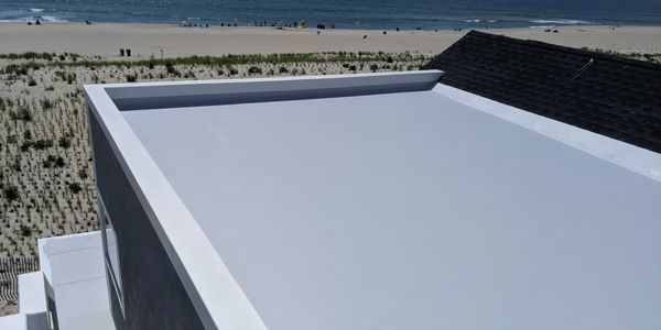 Flat rooftop with ocean view in the background.