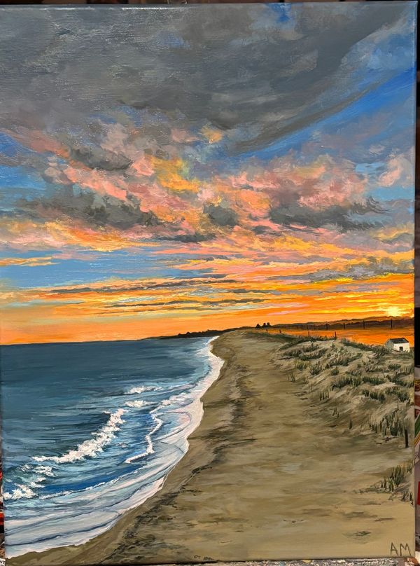 A vibrant sunset over a calm beach with waves gently rolling in.