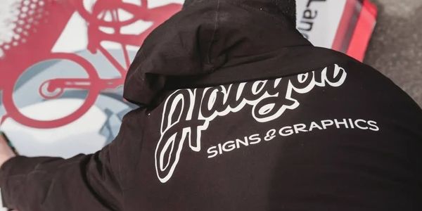 Installation of vinyl print on aluminium sign. 