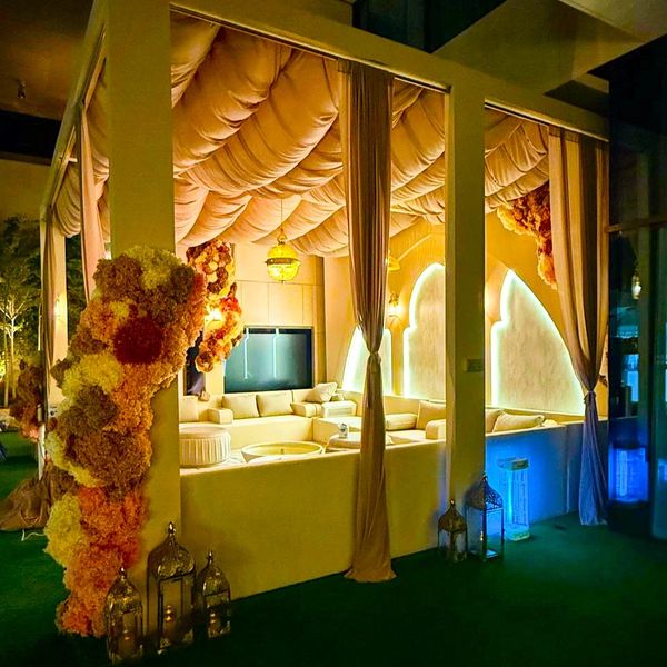 Elegant outdoor lounge with warm lighting and floral accents.