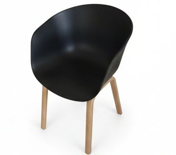 Modern black chair with wooden legs on white background.