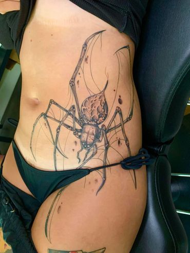 Tattoo of spider on hip