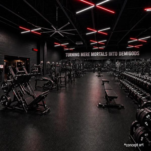 Modern gym with red and white neon lights and motivational slogan on the wall.
