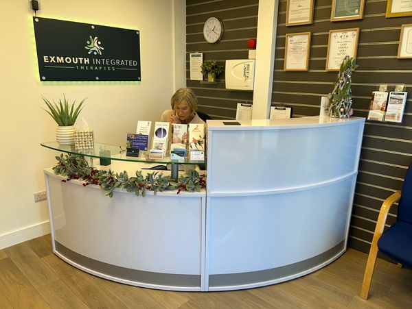 Image of the Exmouth Integrated Therapies Reception area with receptionist and desk