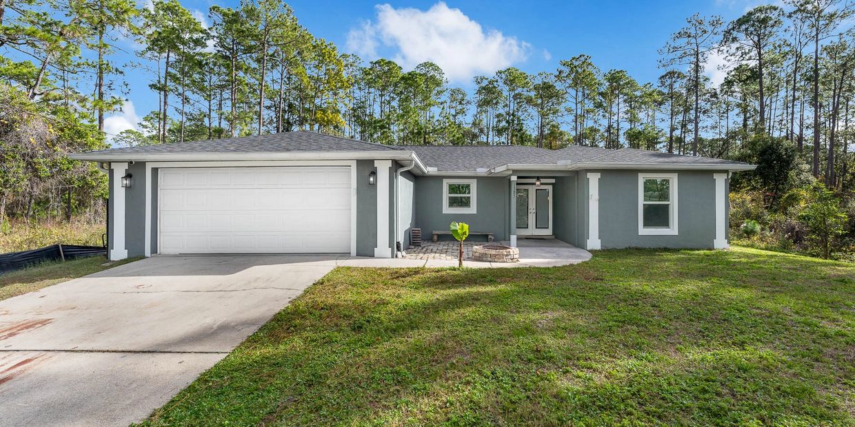 Front of single-story concrete block home at 1385 11th Avenue in DeLand, Florida w/ attached garage