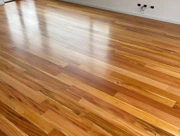 Polished wooden floor with natural grain patterns reflecting light.