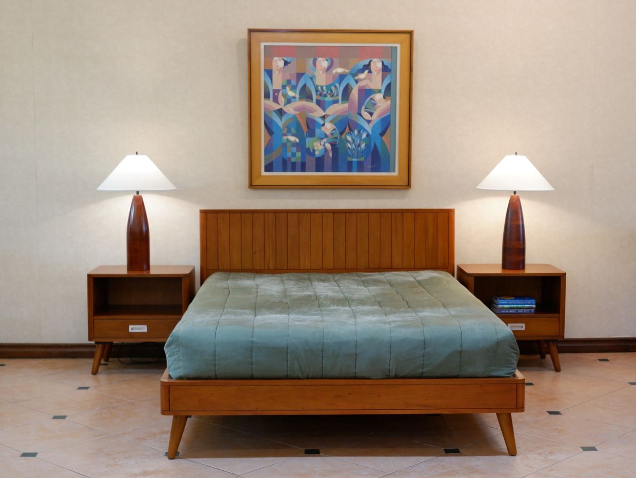 Minimalist bedroom with wooden furniture and soft lighting.