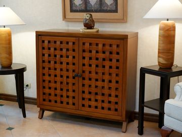 Wooden cabinet with lattice doors flanked by side tables and lamps.
