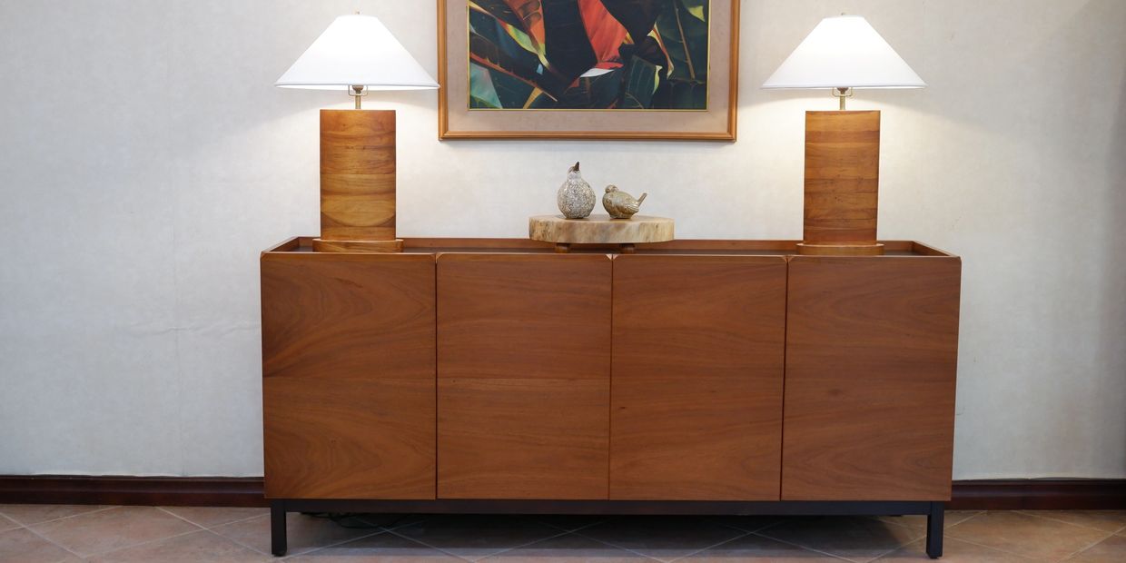 Modern wooden sideboard with two lamps and decorative birds.