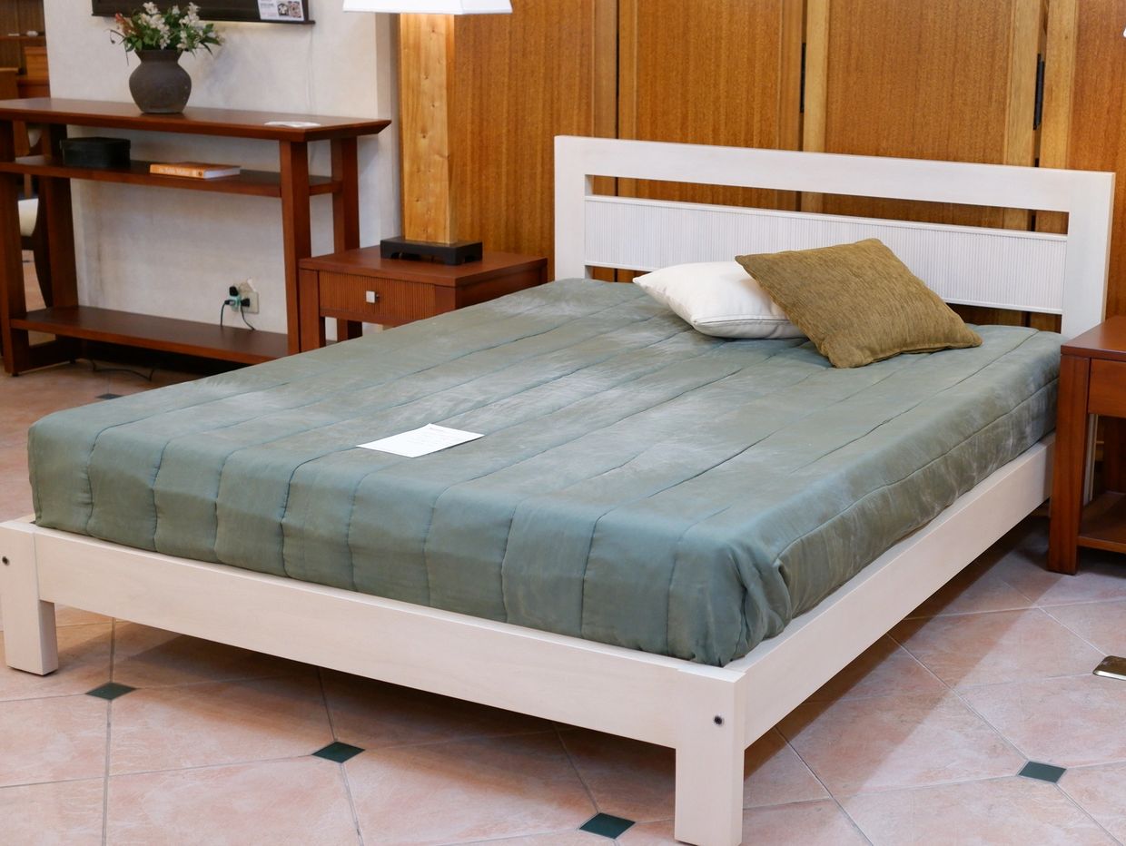 A neatly made bed with two pillows in a cozy room.