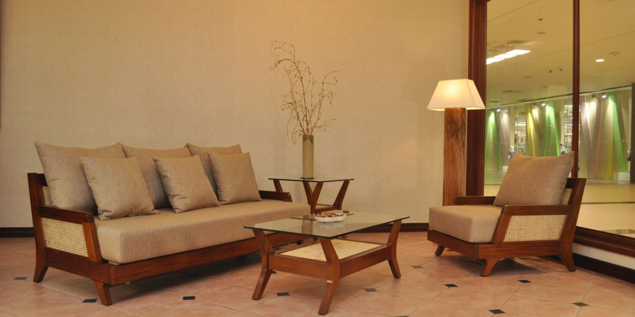 Elegant living room with beige sofa set and wooden furniture.