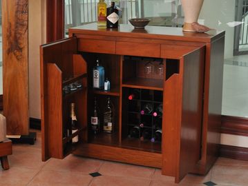 Wooden wine cabinet with open doors showing bottles and glasses.