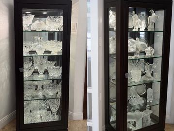 Two glass display cabinets filled with various crystal glassware.
