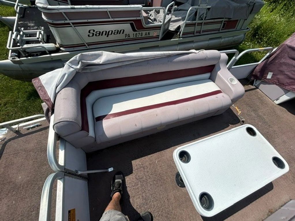 Seating area with a white and maroon bench on a pontoon boat.
