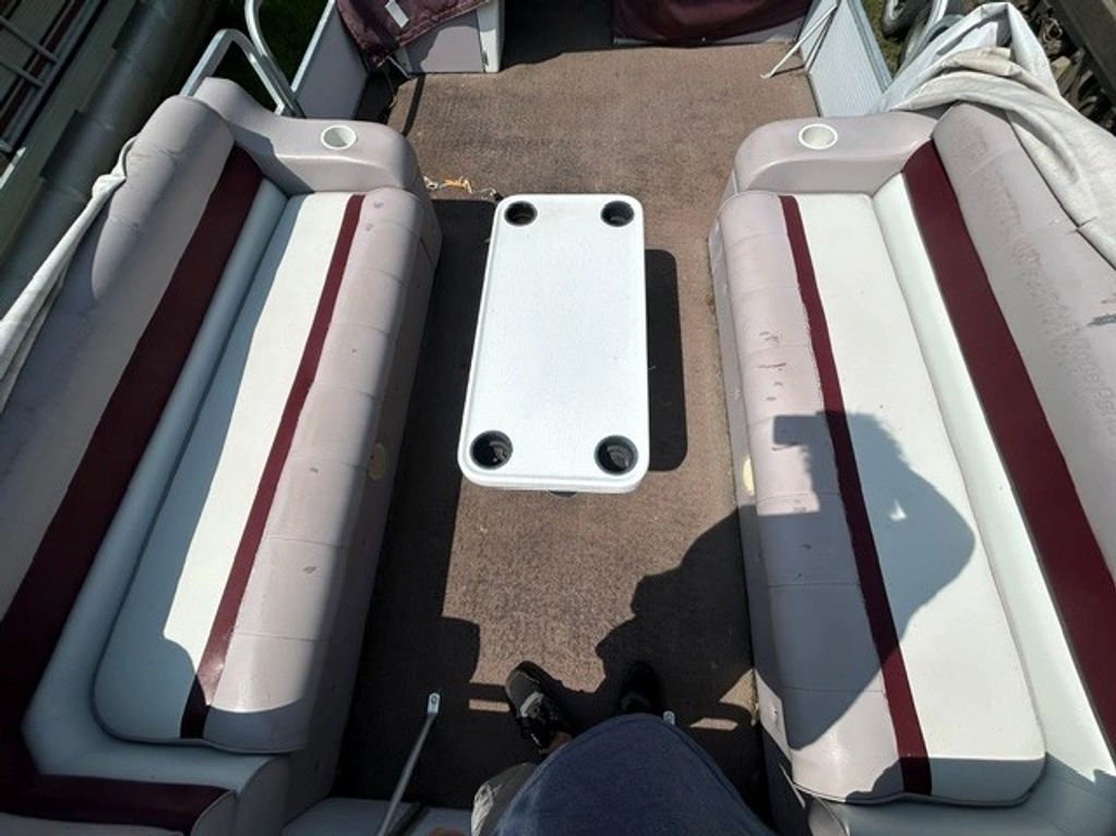 Interior view of a boat with two parallel benches and a central table.