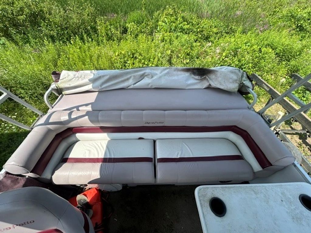 Worn boat seating with grass background.