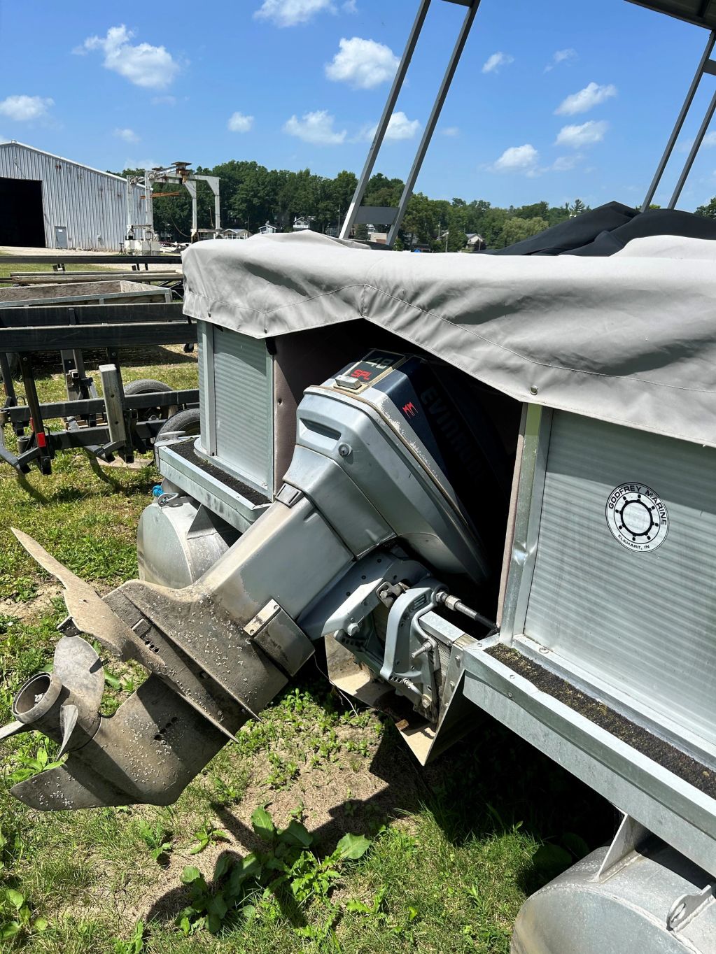 Outboard motor on a covered pontoon boat.