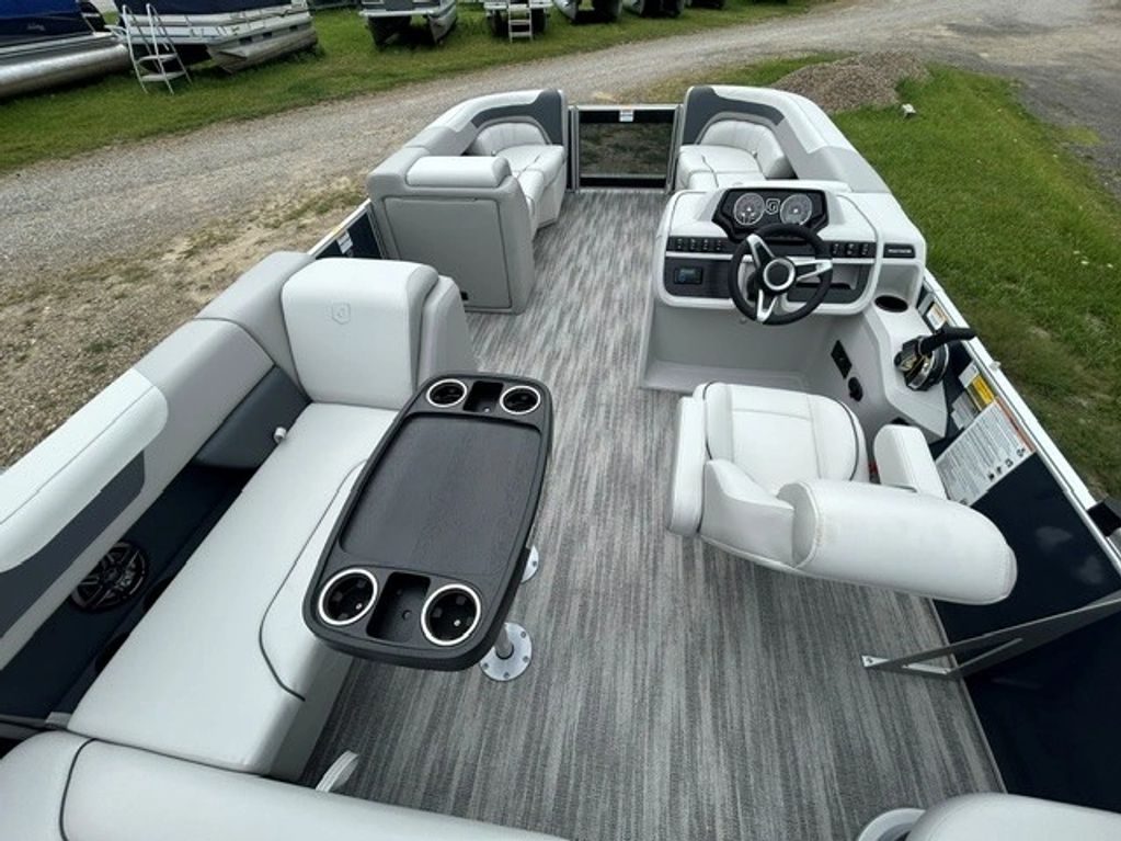 Interior of a grey and white pontoon boat with seats and a table.