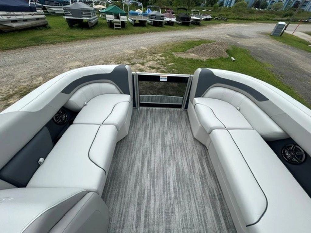 Spacious pontoon boat interior with white cushioned seats.
