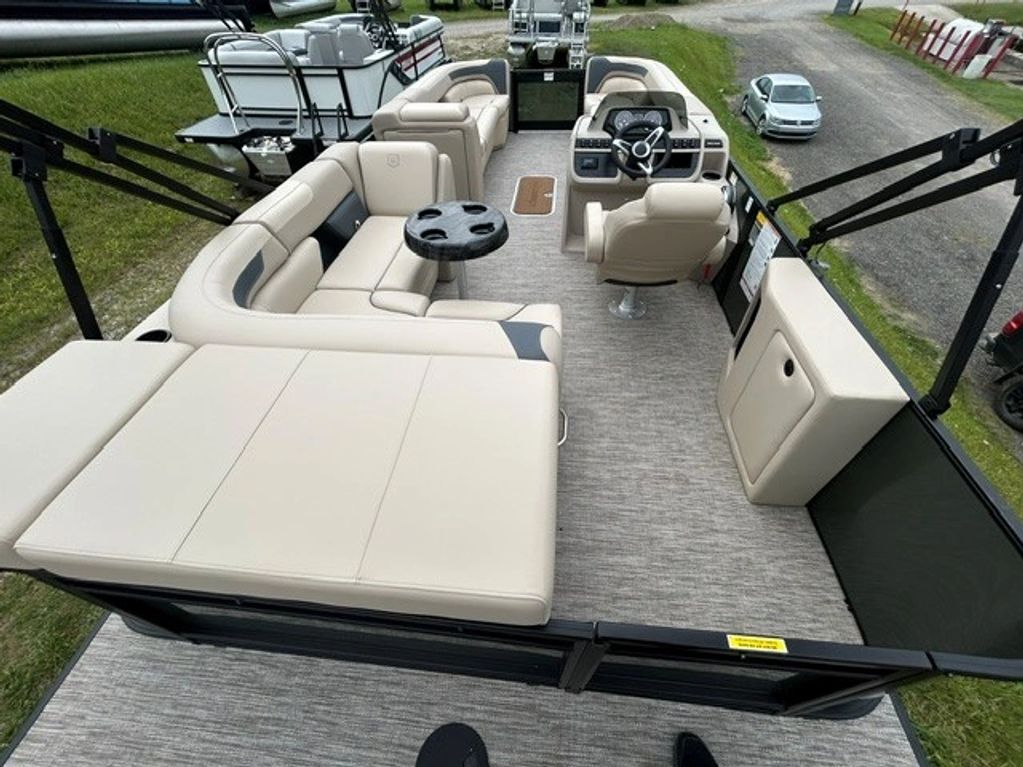 Interior view of a pontoon boat with beige seating and steering console.