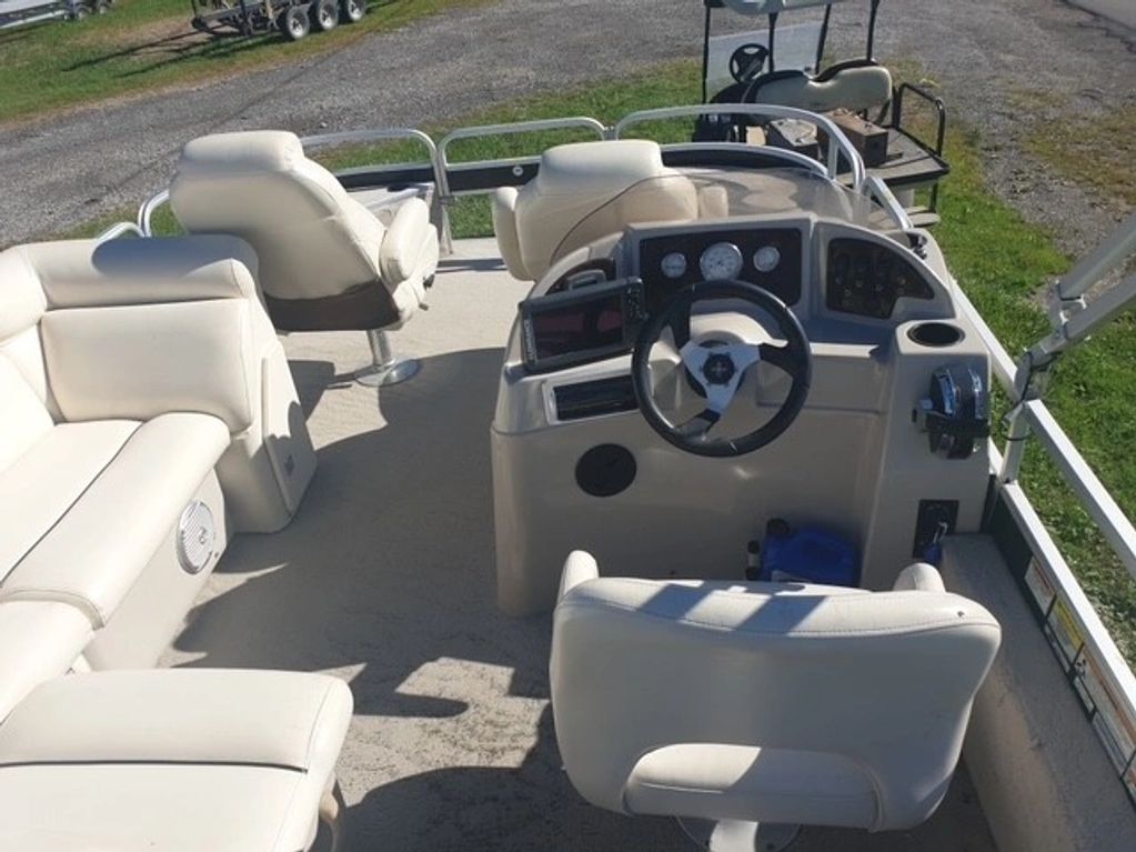 Interior of a boat with beige seats and steering wheel.