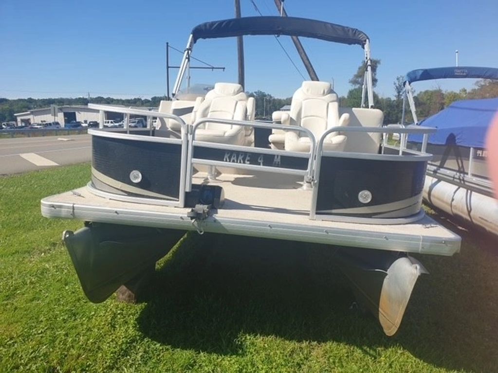 Pontoon boat named Kake 4 H on grass.
