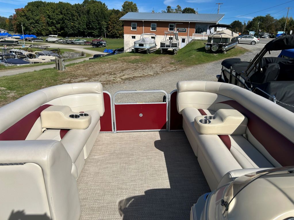 Interior seating area of a pontoon boat with cup holders.