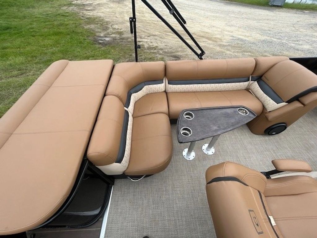 Spacious tan leather seating with a central table on a boat deck.