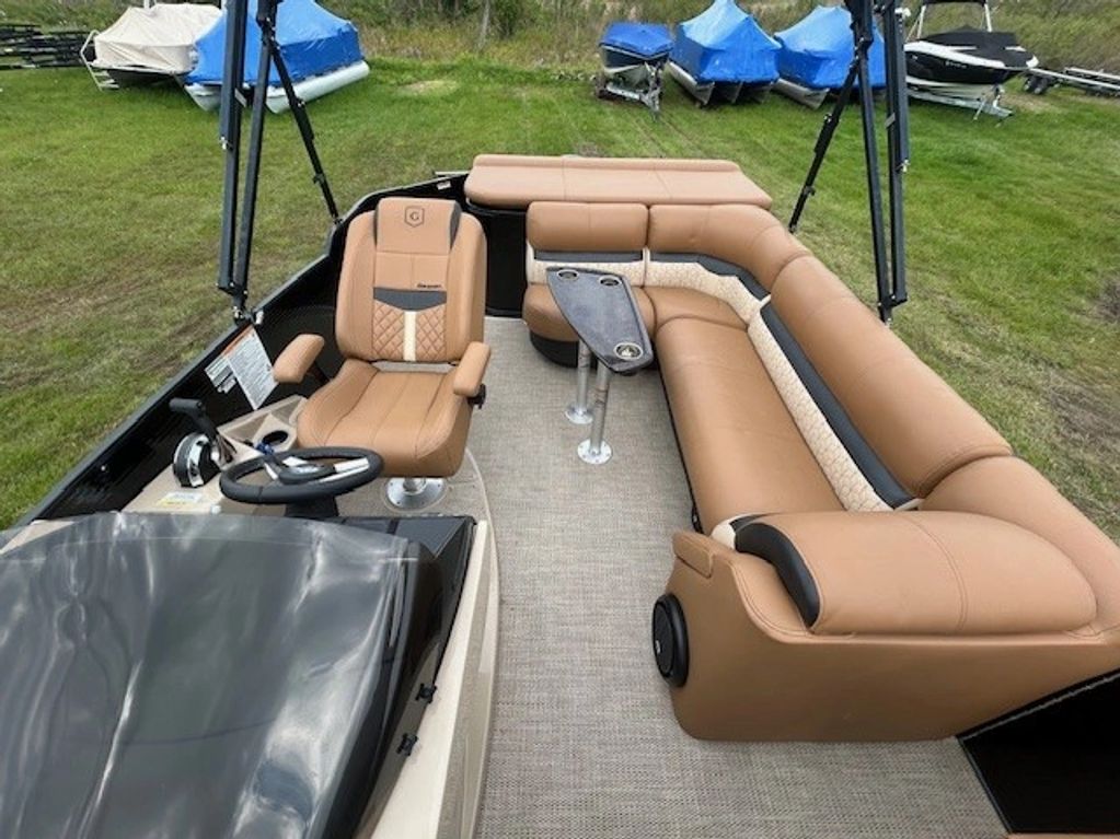 Interior view of a stylish pontoon boat with tan leather seating and a small table.