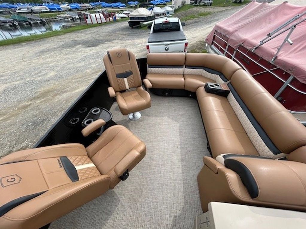 Luxurious tan leather seating on a pontoon boat docked near other boats.