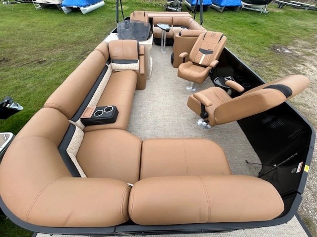 Spacious pontoon boat with tan leather seating and a steering console.