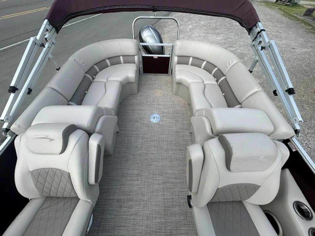 Boating seating area with cushioned seats and a windshield.