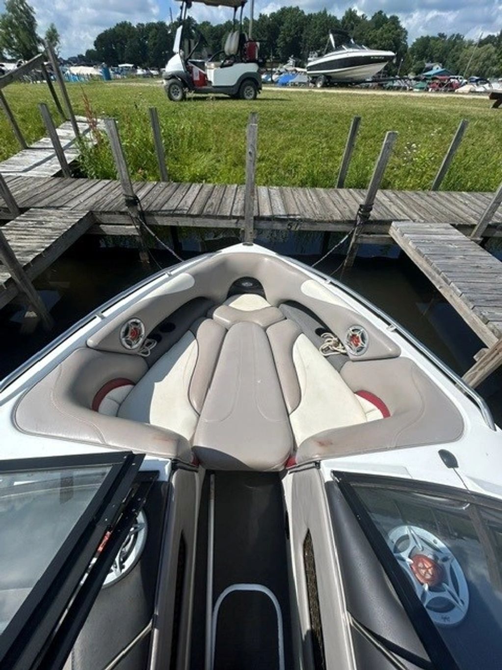 Front seating area of a docked boat on a sunny day.