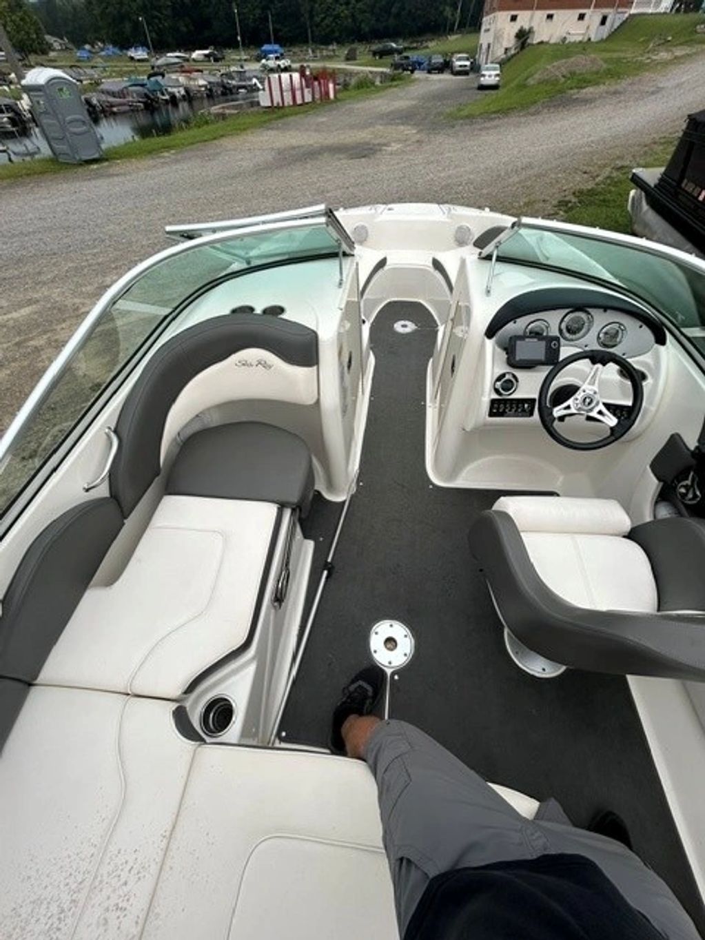 Interior of a parked boat with white and gray seats.
